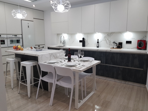 cocina blanca y negra de lineas rectas y modernas con una isla de marmol