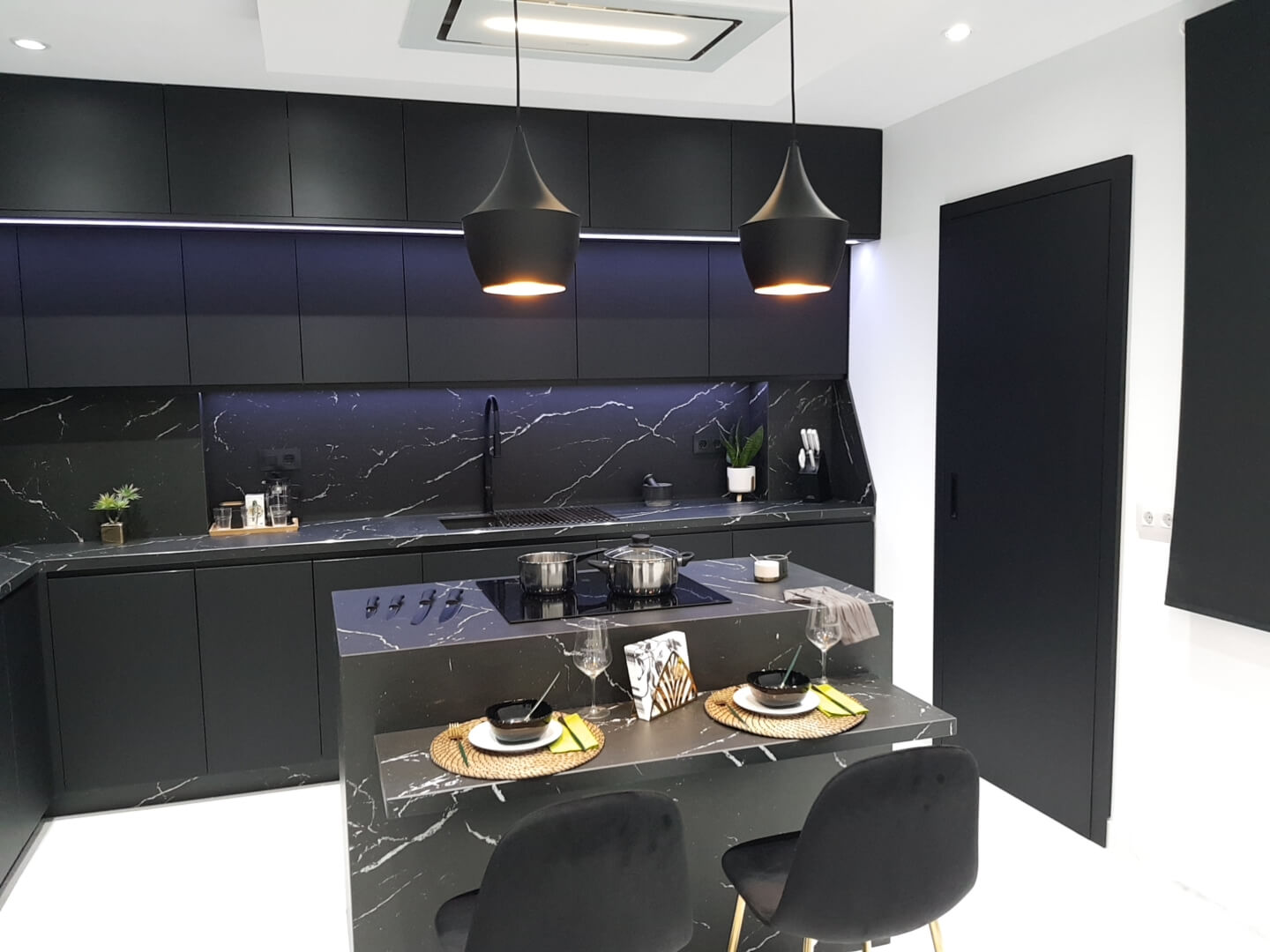 cocina moderna negra con muebles a doble altura con isla central
